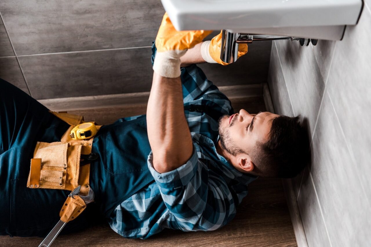 Plumber repairing a slab leaking bathroom sink in a Las Vegas home